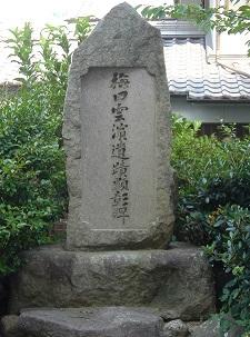 梅田雲浜の碑の周りに緑が生い茂っている写真