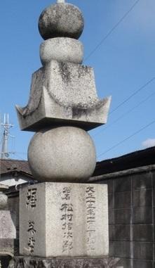 四角い石に文字が描かれており、その上に丸い形をした石や四角い形で先のとがったような石が積まれている写真
