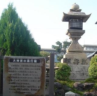 右側に石の灯籠がたち、その横に案内板がある伊勢大神宮の写真