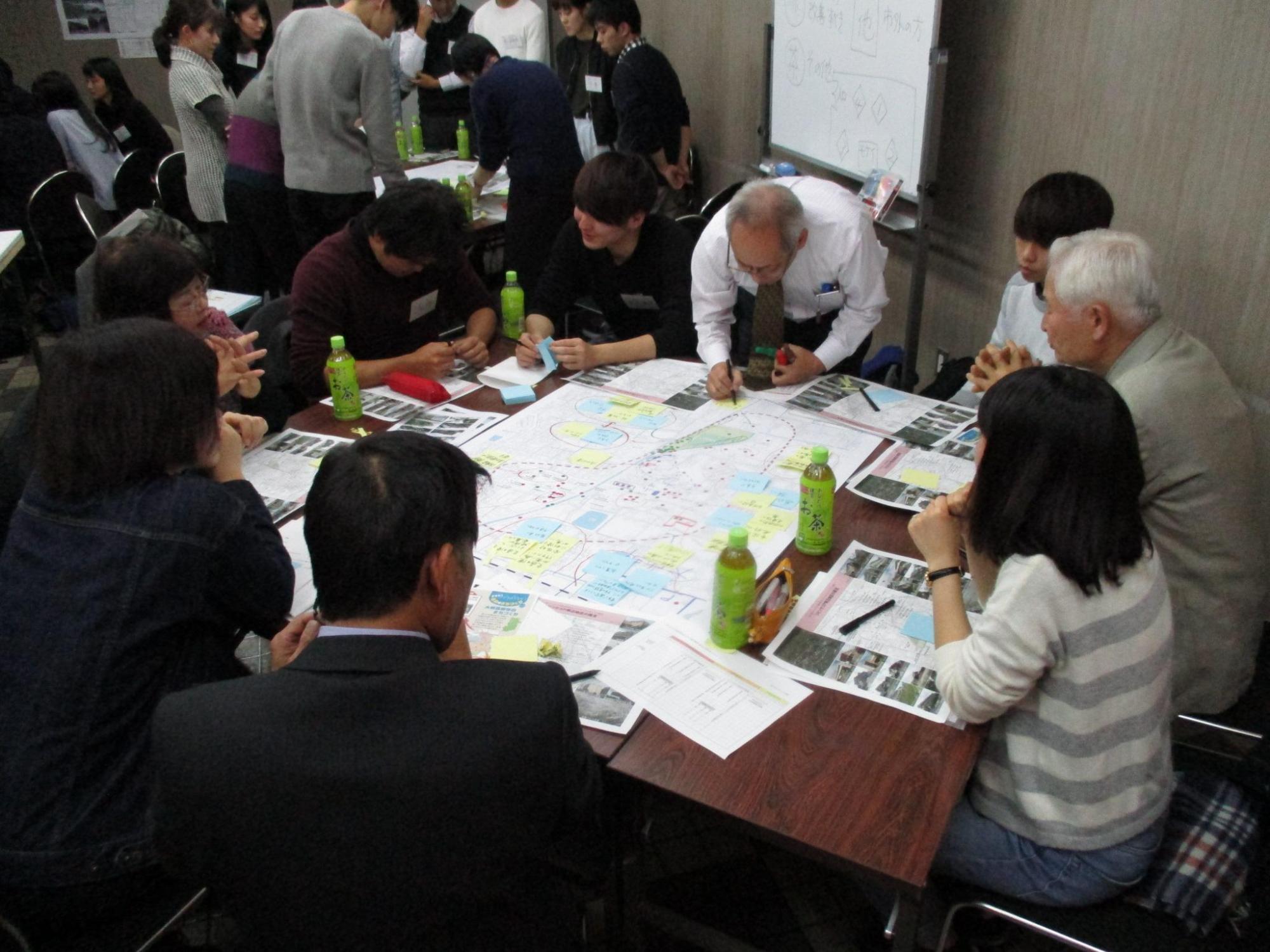 まとめた内容を付箋に記入し机上にある模造紙に貼り資料作成をしている方々の写真
