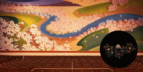 中央奥のに山並みや緩やかな川に沿って満開の桜の花びらが描かれている緞帳の写真