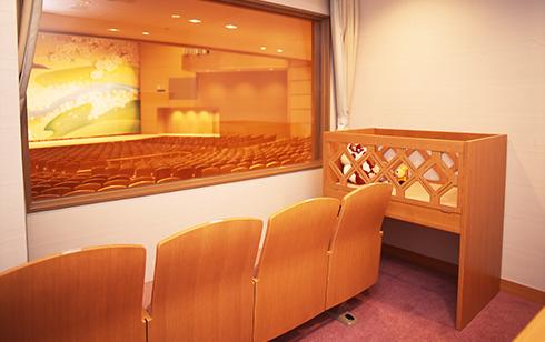 赤ちゃん用のベビーベッドと4脚の椅子が設置されている親子室の写真