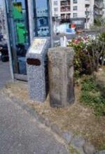 公衆電話の傍に立つ大橋跡に設置された歴史顕彰板の写真
