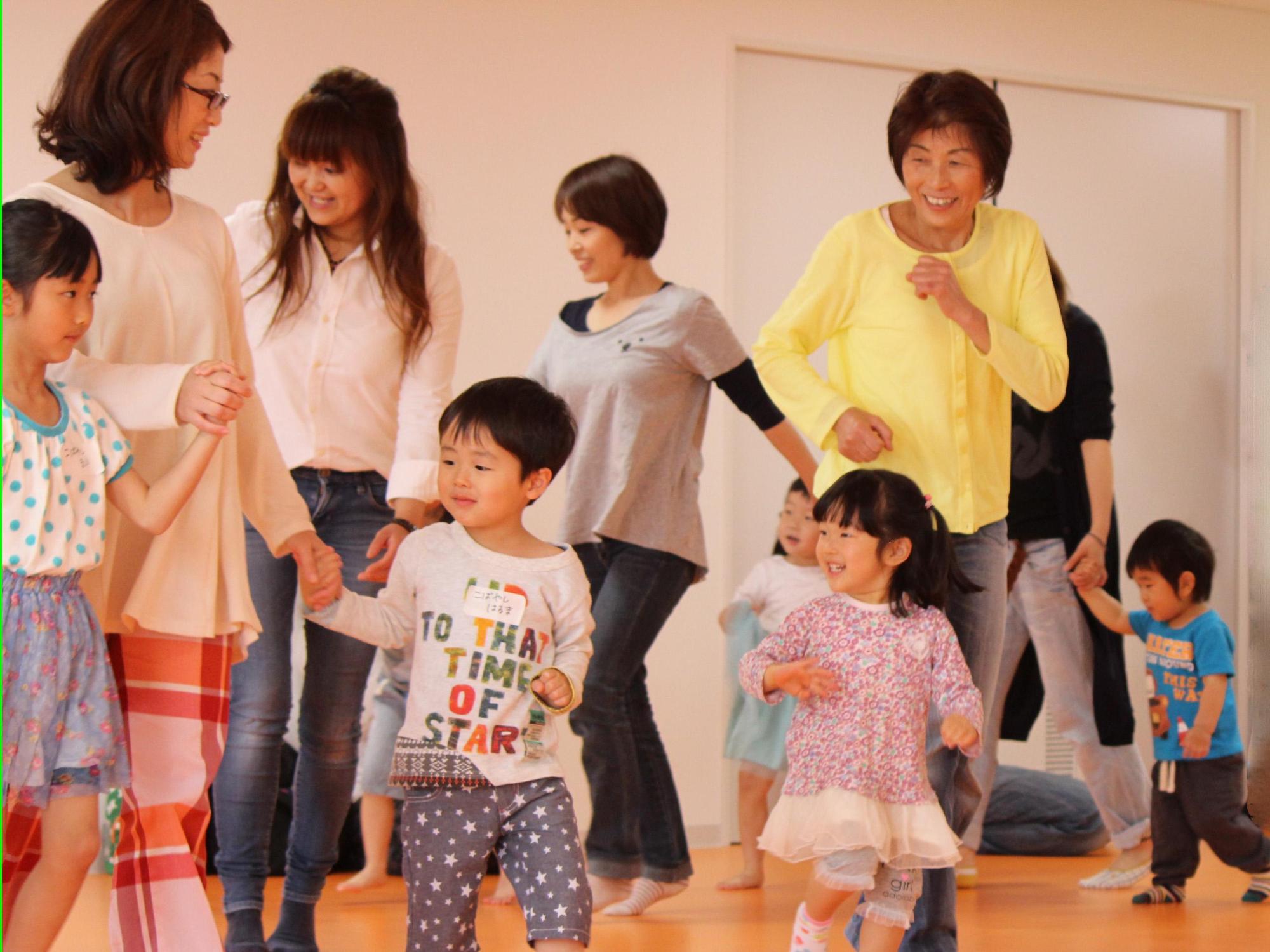 子供達と母親たちが一緒にダンスをしている様子のイベント写真