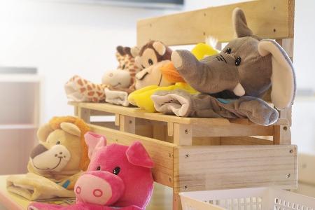 木材で造られた椅子にキリンやライオンやゾウなどのぬいぐるみが置かれた写真