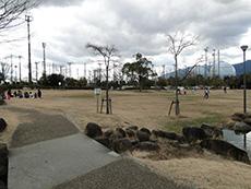 舗装された歩道が芝生の広場に伸びている写真
