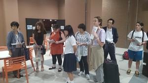 リズモー市の学生達とホストファミリーの人達が話を聞いている写真