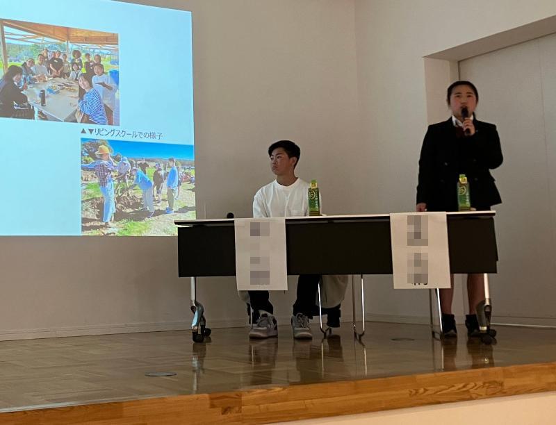 報告会で起立して説明する女子高校生