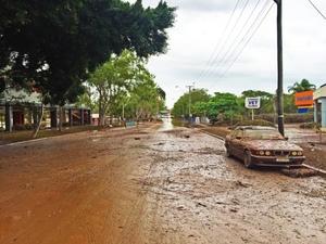 水がはけた後の泥まみれになった道路に停車する1台の泥だらけの車の写真