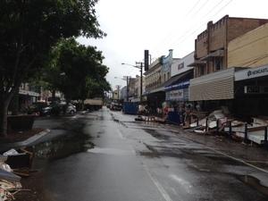 水が引き、道路横に物が散乱している街並みの写真