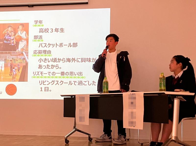 報告会で起立して説明する男子高校生