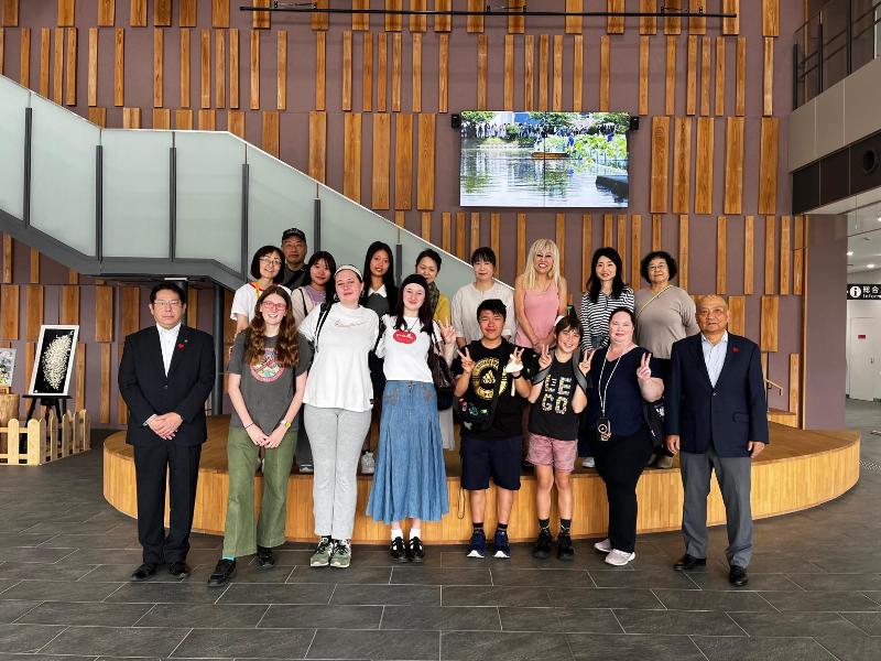 市役所に集まったホストファミリーの皆さんとリズモー市派遣学生で集合写真を撮っている様子