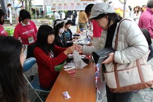学生から購入したラミントンを受け取っている女性の写真