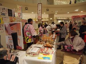 販売ブースで品物を手に取り、買い物をしている参加者達の写真