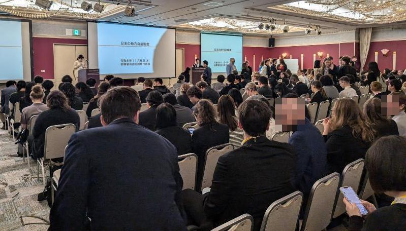 たくさんの参加者が椅子に座って研修を受けている様子