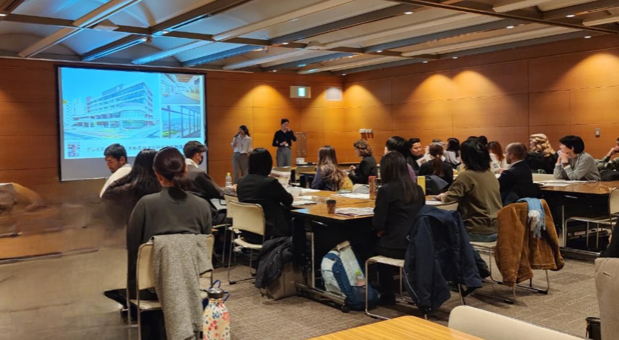 研修会の開場で大勢の参加者前で、パワーポイントを用いて大和高田市を紹介する国際交流員のカレスグレイスさん