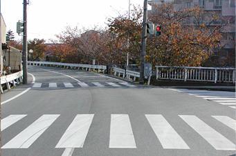 交差点の右奥に団地が見える道路の写真