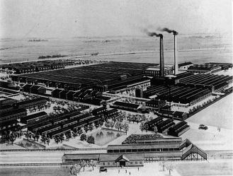 大日本紡績の工場建物が並び2つの煙突から煙が出ている様子を上空から写した白黒写真