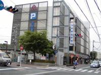 道路沿いに建つ高田駅西側駐車場ビルの外観写真