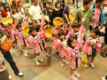 お揃いのピンクの法被をきた園児がおかげ祭りで踊りを披露している写真