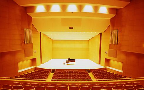 ステージ中央にグランドピアノが置いてあるのを2階の客席から撮影した写真