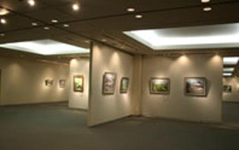 ホールの中央に仕切りが設置され、2点ずつ絵画の作品が展示されている写真