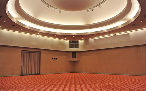 絨毯敷きで天井に大きな円形の照明が設置されている写真