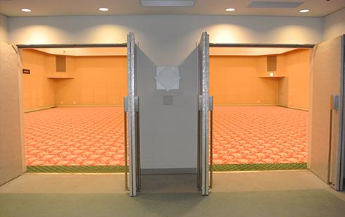 絨毯敷きの明るい室内のレセプションホールの入り口の扉を開放している写真