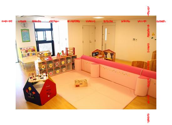 カラフルな玩具やピンクのマットが置かれた託児室内の写真