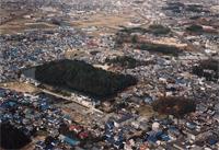 円墳の周囲に民家が立ち並んでいるコンピラ山古墳を南東上空から撮影した写真
