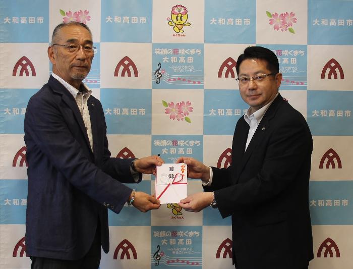 寄附目録贈呈式の模様（高田鋼材工業株式会社 松村代表取締役社長(左)と堀内市長(右)）