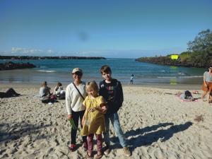砂浜で外人の男の子と女の子と一緒に記念撮影をしている女子学生の写真