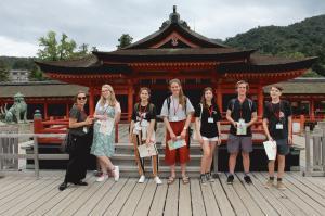 厳島神社の前で記念撮影をしているリズモー市の6名の学生と1名の引率者の写真