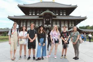 東大寺の 大仏殿前で記念撮影をしているリズモー市の6名の学生と1名の引率者の写真