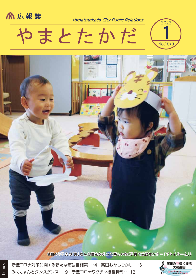広報誌1月号表紙 子育て支援センターで令和4年の干支の「寅」さんのお面をかぶって遊ぶ二人の子どもたちの様子