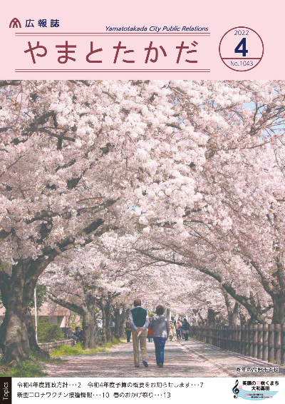 広報誌4月号表紙 高田千本桜の桜のトンネルの中を歩く老夫婦の様子