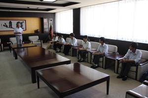 各1人ずつ椅子に座り市長の話を聞いている学生達の写真