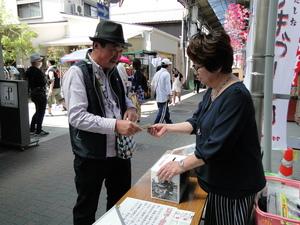 男性が女性に募金のお札を手渡ししている写真