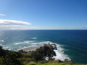 真っ青な空に白い雲、崖の下にはエメラルドグリーンの海が広がっている写真