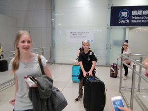 外国人の派遣学生が大きな荷物を持ち空港改札ゲートから出て来ている写真