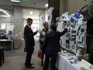 ギャリー・マーフィー氏とジェニー・ドウェル市長が展示されている写真を見ている写真を