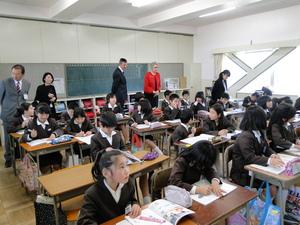 小学生が授業を受けている様子を教室の後方から見学しているギャリー・マーフィー氏とジェニー・ドウェル市長の写真