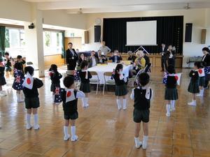 園児達が日本とオーストラリアの小さな国旗を使い踊りを披露している写真