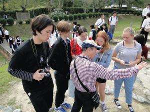 明日香村の説明をカメラ片手に聞いているリズモー市からの学生5名の写真