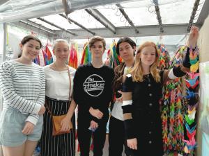 折った鶴をつなげ記念撮影をしているリズモー市の女子学生3名と男子学生2名の写真
