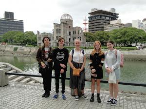 広島平和記念公園で記念撮影をしているリズモー市の女子学生3名と男子学生2名の写真