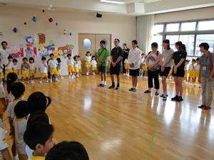 土庫こども園の園児達が囲んでいる真ん中にリズモー市の学生たちが一列で並んでいる写真