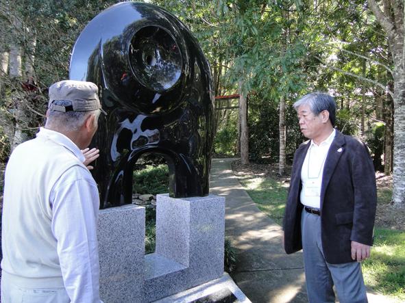 記念碑の説明をしている男性の話を聞いている市長の写真