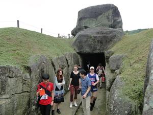 明日香村の岩のトンネルを通っているリズモー市の学生たちの写真