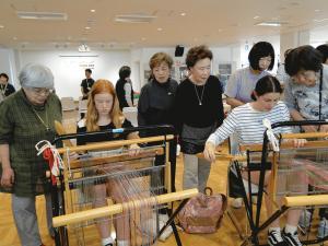 機織りの体験をしているリズモー市の女子学生2人の写真